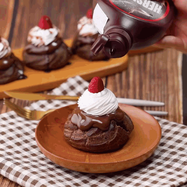 a bottle of hershey chocolate syrup is being poured on a chocolate dessert