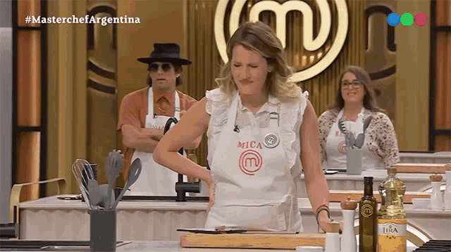 a woman wearing a white apron that says mica