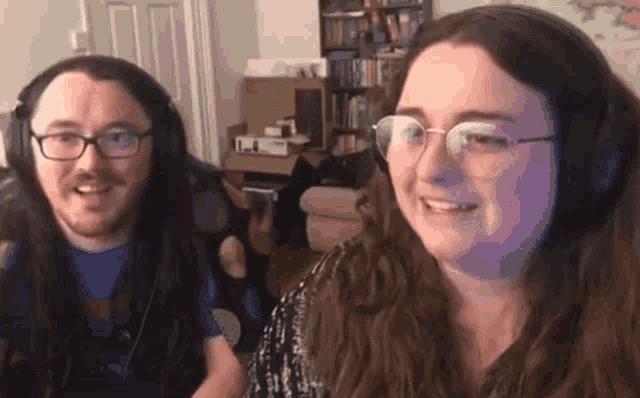 a man and a woman wearing headphones and glasses are smiling