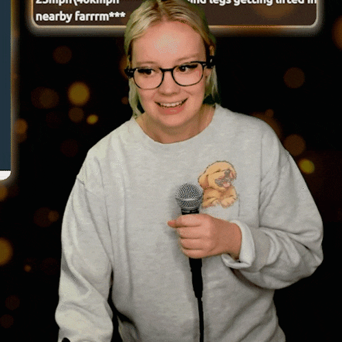 a woman wearing glasses is holding a microphone in front of a sign that says nearby farrrm ***