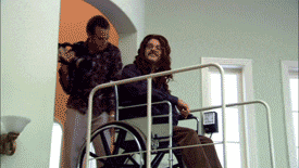 a man pushing a woman in a wheelchair up a set of stairs