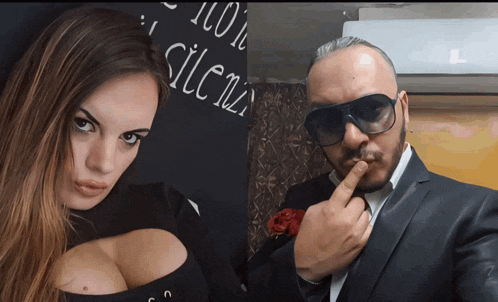 a man and a woman are posing for a picture in front of a sign that says silenzio