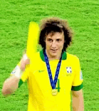 a soccer player wearing a yellow shirt and a medal around his neck is holding a yellow fan .