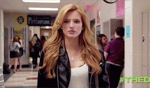 a woman in a leather jacket stands in a hallway with a sign that says pitchfork