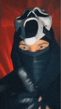 a person wearing a mask and gloves with a scream mask on their head