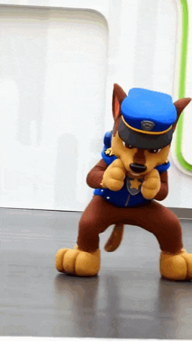 chase from paw patrol is wearing a police uniform and dancing on the floor .
