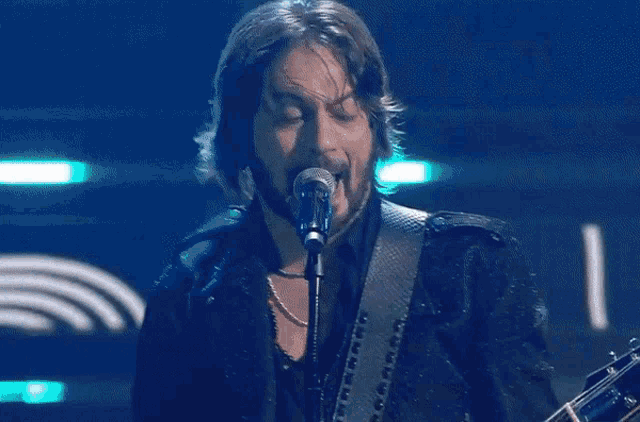 a man singing into a microphone with the words tantissimoo000 written below him