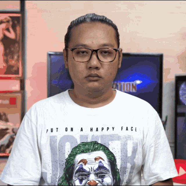 a man wearing glasses and a white shirt that says " put on a happy face "