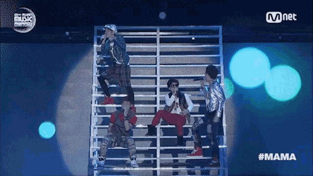 a group of people singing on a stage with the hashtag mama