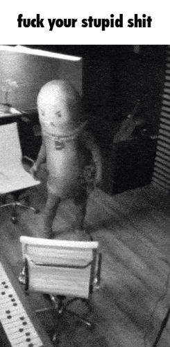 a black and white photo of a man standing next to a chair with the words fuck your stupid shit below him