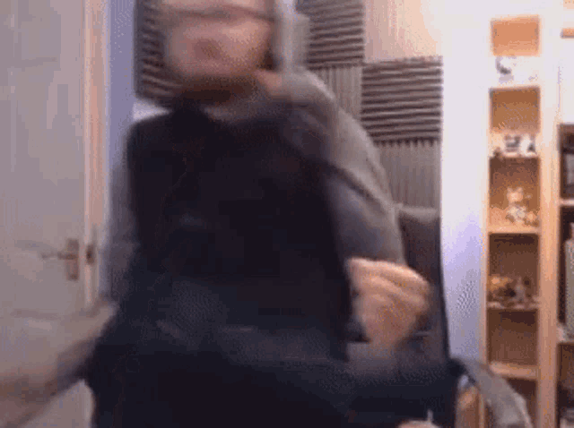 a blurry picture of a man sitting in a chair in a living room .