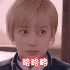 a young boy with blonde hair is making a funny face with chinese writing on his face .