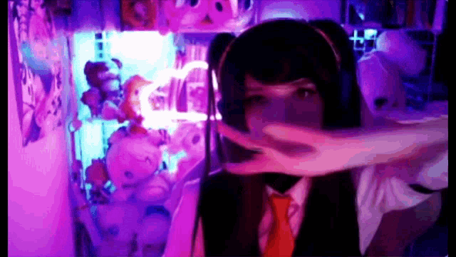 a girl wearing a headset and a tie is making a peace sign
