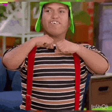 a man in a striped shirt and red suspenders is making a funny face .
