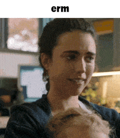 a close up of a woman holding a baby with the word erm below her