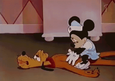 a cartoon of mickey mouse and pluto laying on the ground