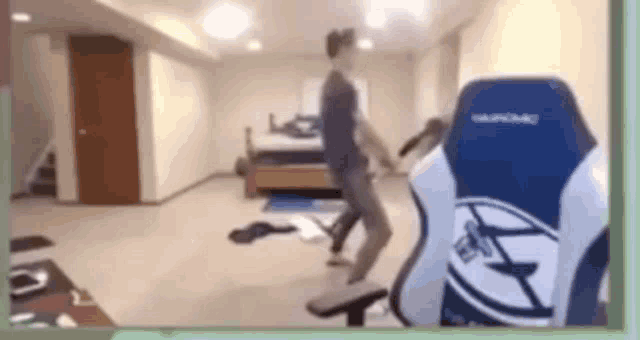 a man is standing in front of a gaming chair in a basement .