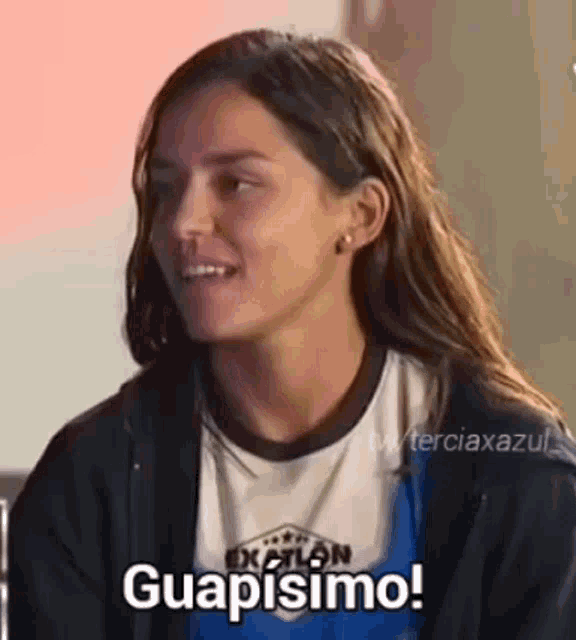 a woman with long hair is wearing a hoodie and a t-shirt and is smiling .