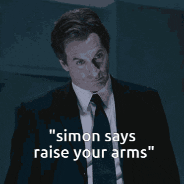a man in a suit and tie says simon says " raise your arms "