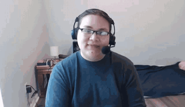 a man wearing headphones and a microphone is smiling