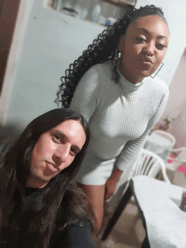 a man and a woman pose for a picture in a kitchen