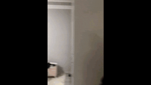 a person is walking through a doorway in a bedroom .