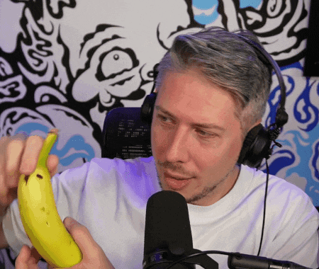 a man is wearing headphones and holding a banana in front of a microphone
