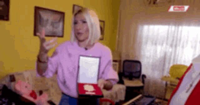 a woman is holding a plaque in a living room .