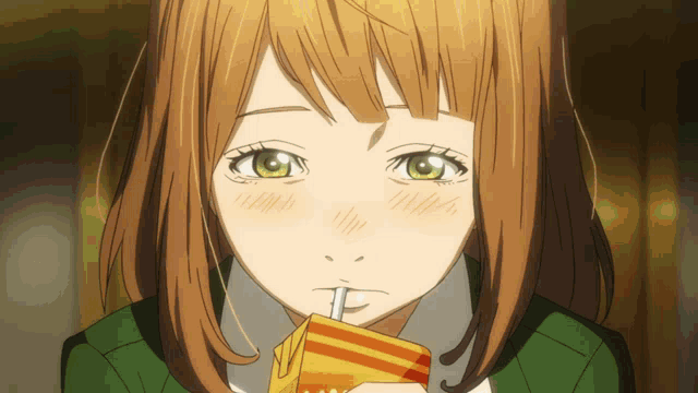 a girl with brown hair is drinking from a carton with a straw