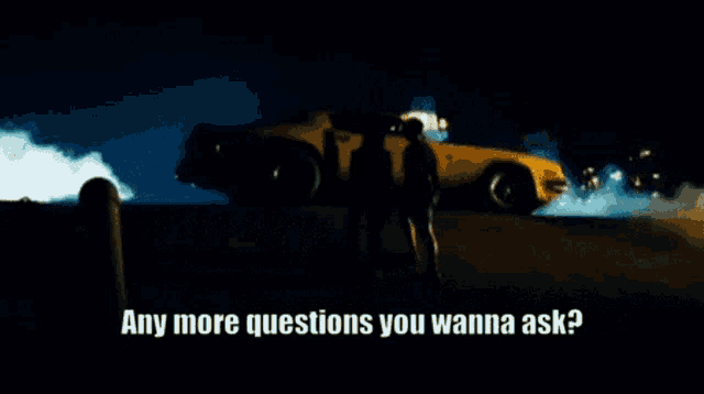 a man is standing in front of a yellow car and says any more questions you wanna ask .