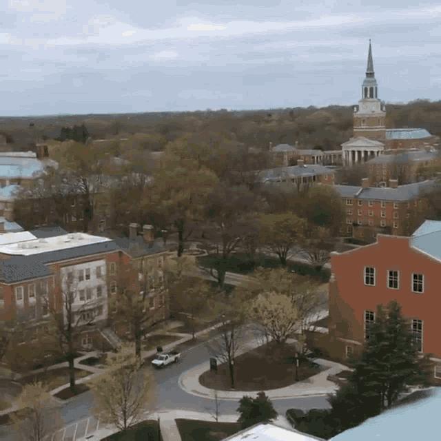 an aerial view of a city with a church steeple in the distance
