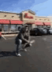 a person is squatting in front of a chick fil a restaurant