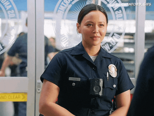 a female police officer stands in front of a door that says ' no clear '