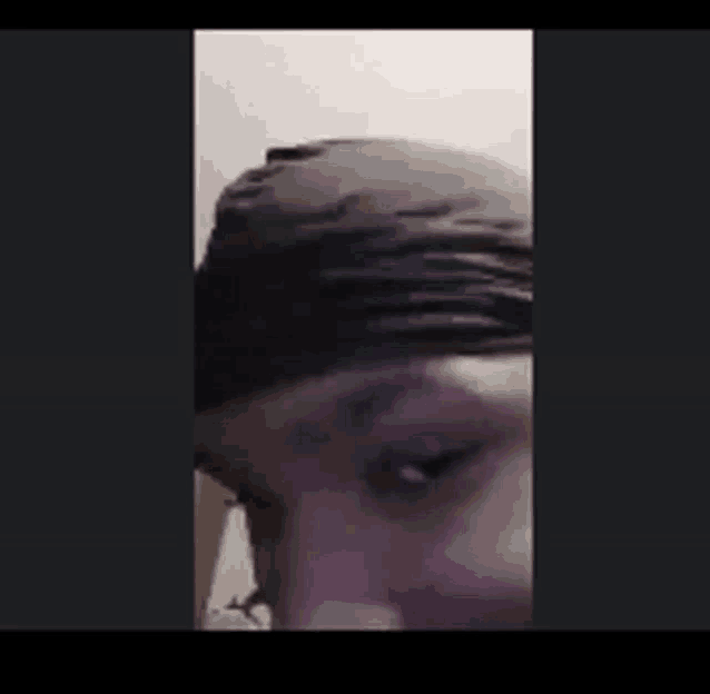 a close up of a person 's face with a black hat on