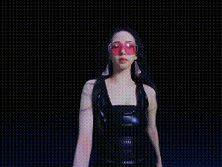 a blurred image of a woman 's face and arms in a dark room .