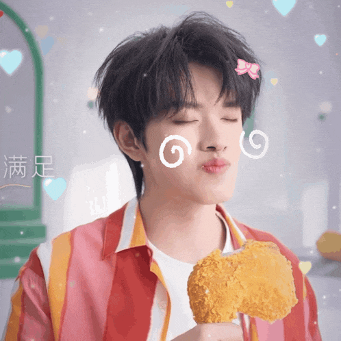 a young man eating a fried chicken wing with chinese writing on his face