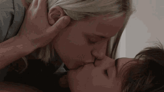 a man and a woman are kissing in a bedroom