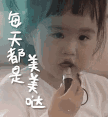 a little girl is applying lipstick to her lips with chinese writing in the background .
