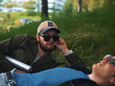 a man wearing sunglasses and a baseball cap with the letter b on it