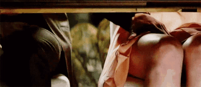 a man and a woman are having sex under a table in a room .