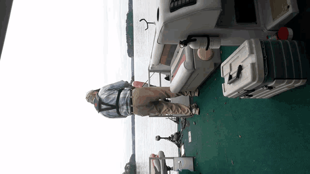 a man is standing on a boat looking out over the water