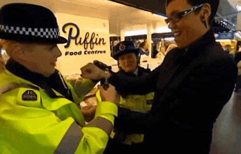 two police officers are talking to a man in front of a sign that says puffin food centres