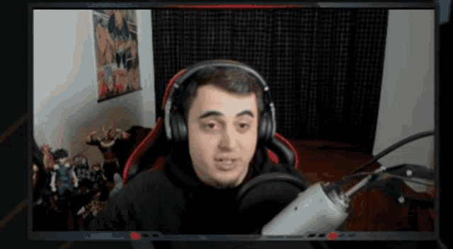 a man wearing headphones is sitting in front of a microphone ..