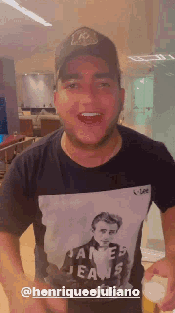 a man wearing a james jeans t-shirt and a hat