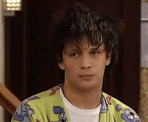 a young man wearing a colorful shirt with a cartoon character on it