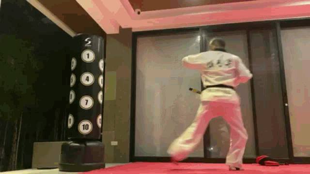 a person is upside down in front of a punching bag that says 10 on it