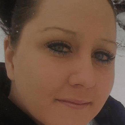 a close up of a woman 's face with snow on her hair .