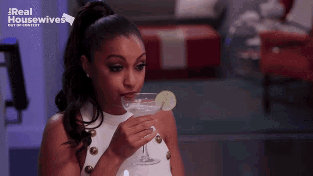 a woman drinking from a martini glass with the words real housewives out of context on the bottom
