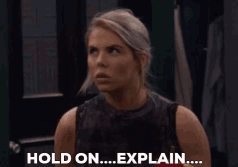 a woman is standing in front of a door and says hold on explain