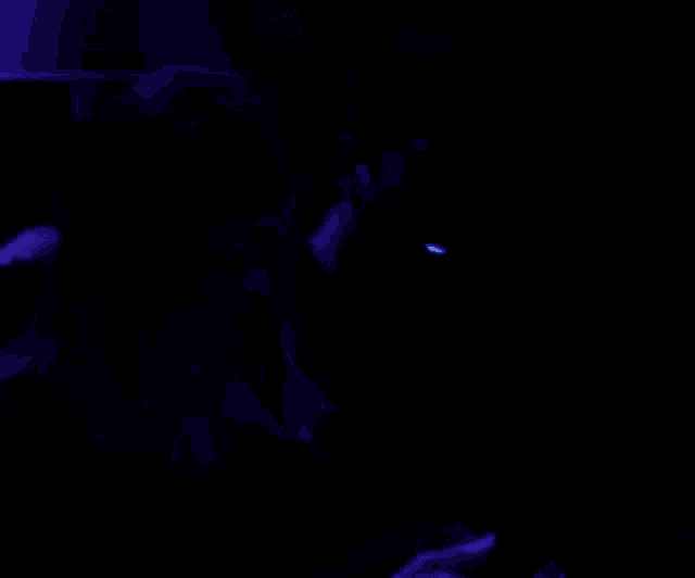 a person 's face is glowing in the dark under a lamp